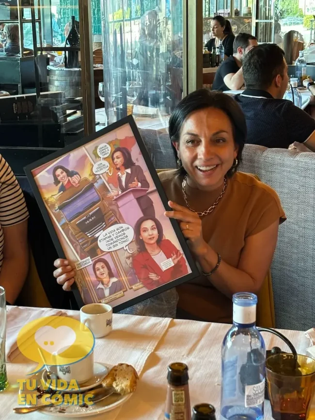 Reacción de la directiva y compañera de trabajo al recibir su regalo de despedida en forma de cómic personalizado con su historia laboral. Emoción y lágrimas.