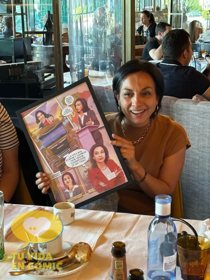 Reacción de la directiva y compañera de trabajo al recibir su regalo de despedida en forma de cómic personalizado con su historia laboral. Emoción y lágrimas.