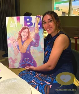 Fotografía real de Alba posando con su regalo de graduación: una ilustración personalizada realizada por Borja Ben para tuvidaencomic.com. Emoción, logro y sonrisa.