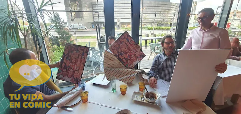 Compañeros de trabajo posando felices con su lámina de ilustración personalizada. Reacción al recibir un regalo de despedida original y emotivo